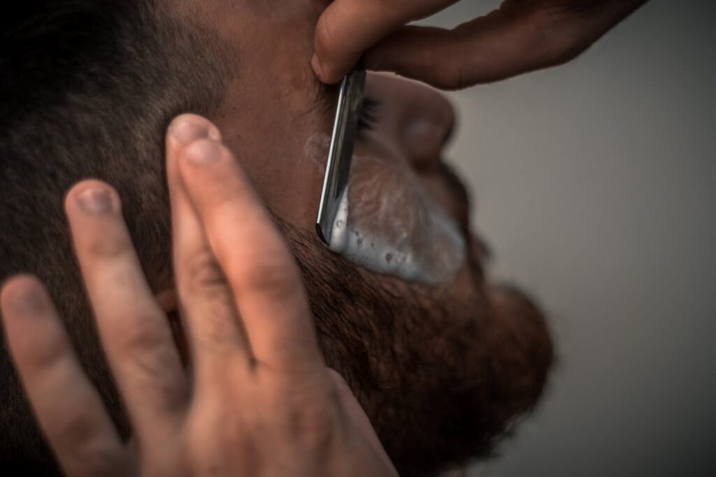 De contouren van een baard worden met een open mes verzorgd